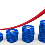 Increasing stack of blue chips with a rising red arrow.