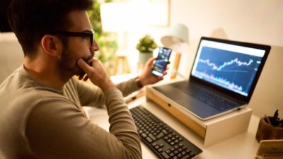 Broker looking at the share price on his laptop.