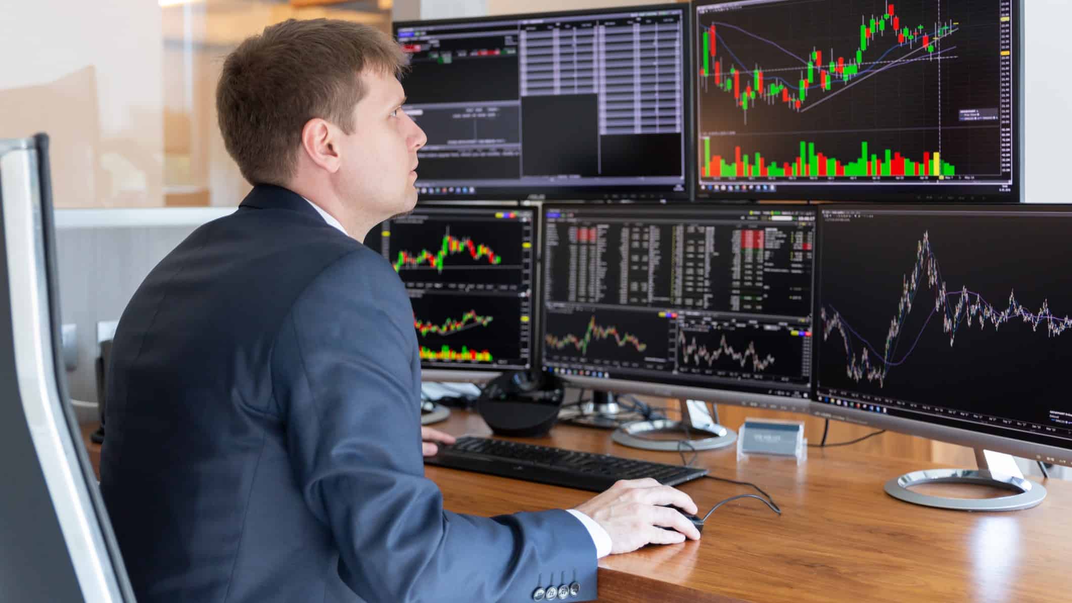 Broker working with share prices on computers.