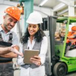 Two happy construction workers discussing share price performance with each other.
