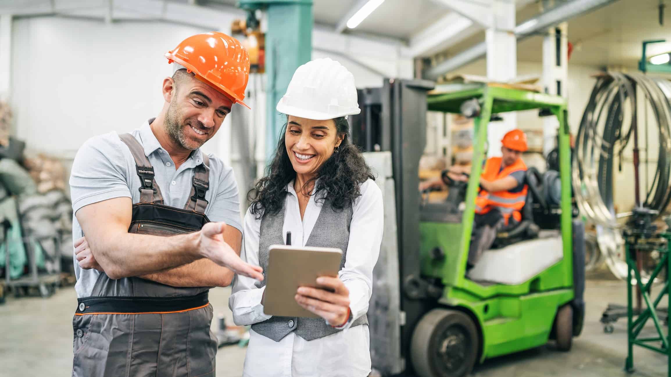Two happy construction workers discussing share price performance with each other.