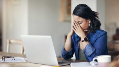 Woman disappointed at share price performance with her hands on her face.