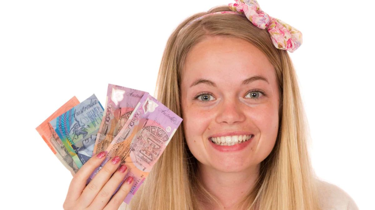 Woman holding Australian dollar notes symbolising dividends.