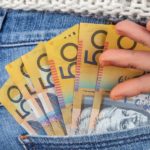 $50 dollar Australian notes in the back pocket of jeans representing dividends.