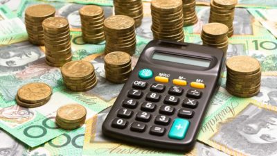 Calculator on top of Australian 4100 notes and next to Australian gold coins.