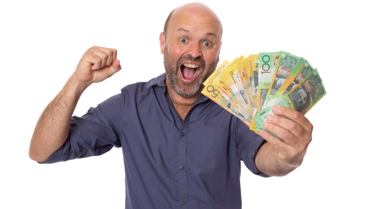 Happy man holding Australian dollar notes, representing dividends.