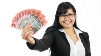 Woman holding out $20 dollar Australian notes, symbolising dividends.