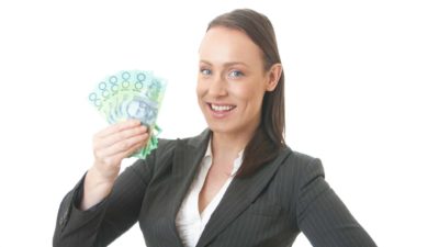 Woman holding $100 Australian notes representing dividends.