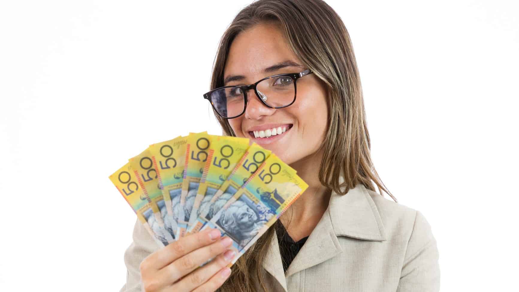 Woman holding $50 notes and smiling.