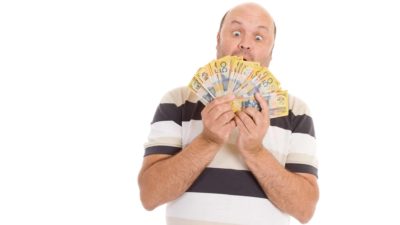 Man looking amazed holding $50 Australian notes, representing ASX dividends.