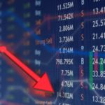 Red arrow going down on a stock market table which symbolises a falling share price.