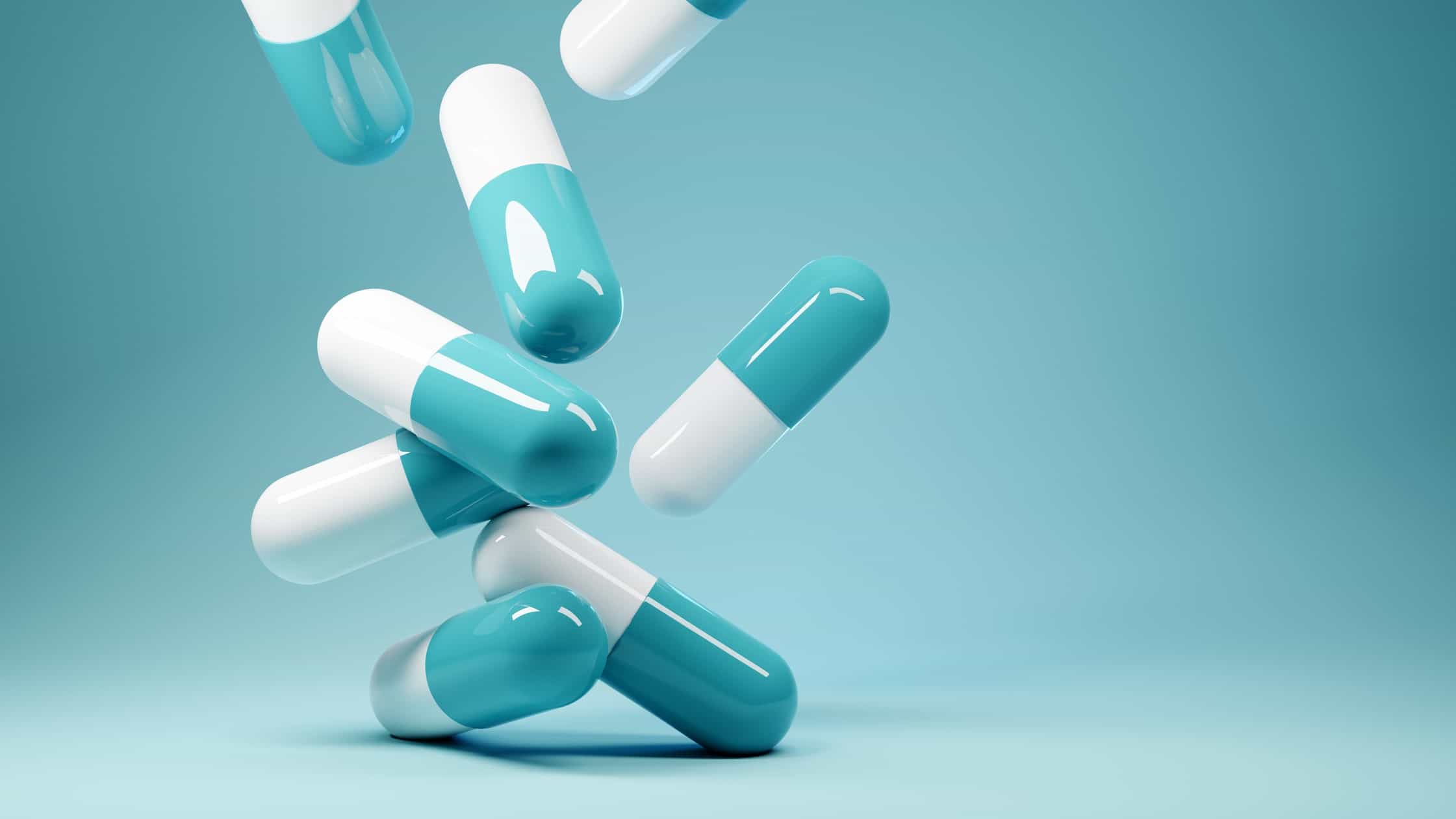 Falling pills in a blue background symbolising a falling share price.