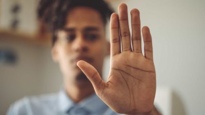 Man with his hand out the front, symbolising a trading halt.