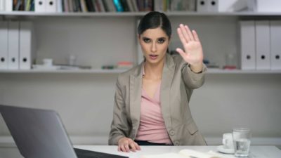 Woman holding out her hand, symbolising a trading halt.