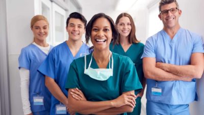 Five healthcare workers standing together and smiling.