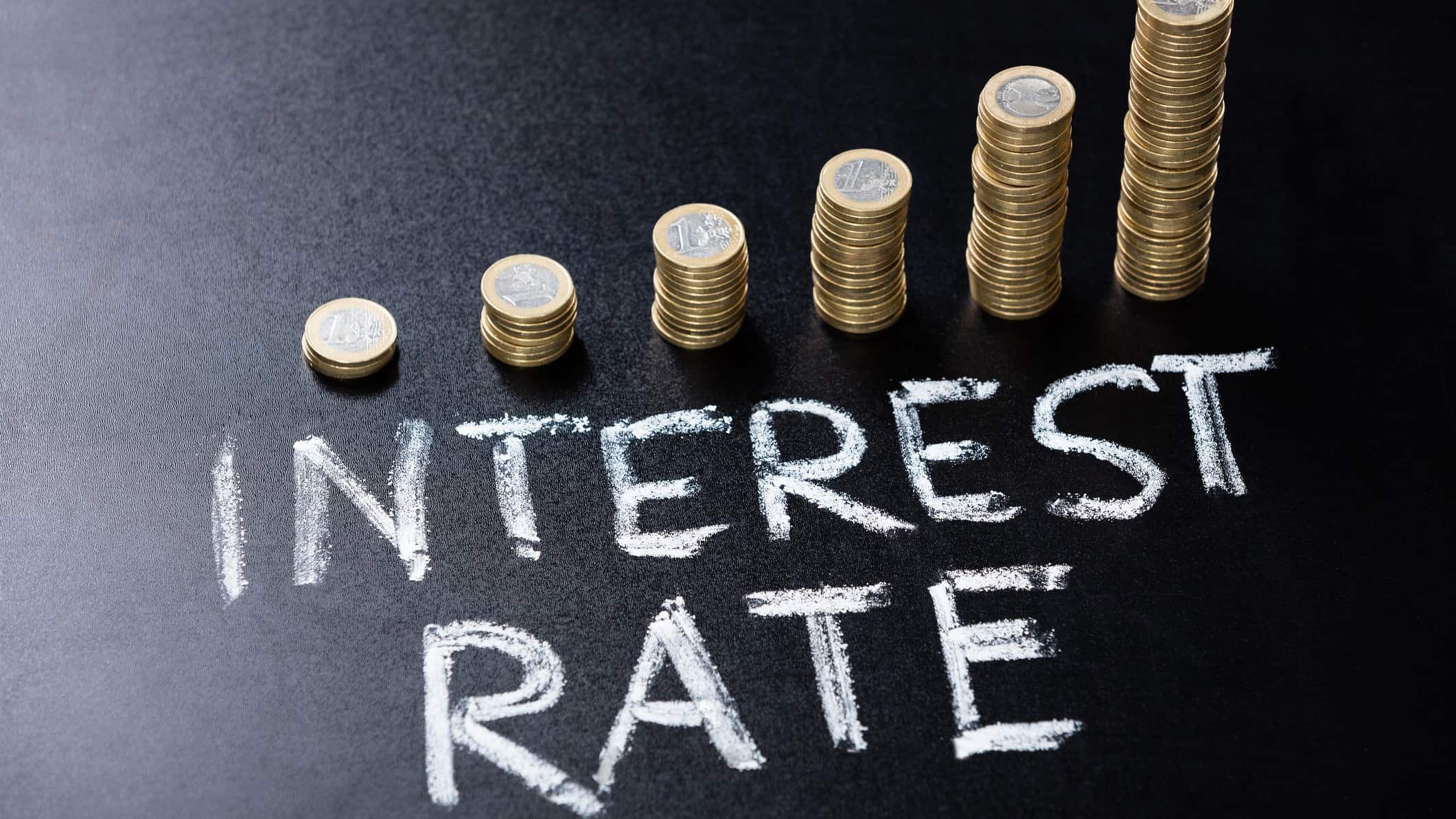 Interest rate written in white with an increasing pile of coins.