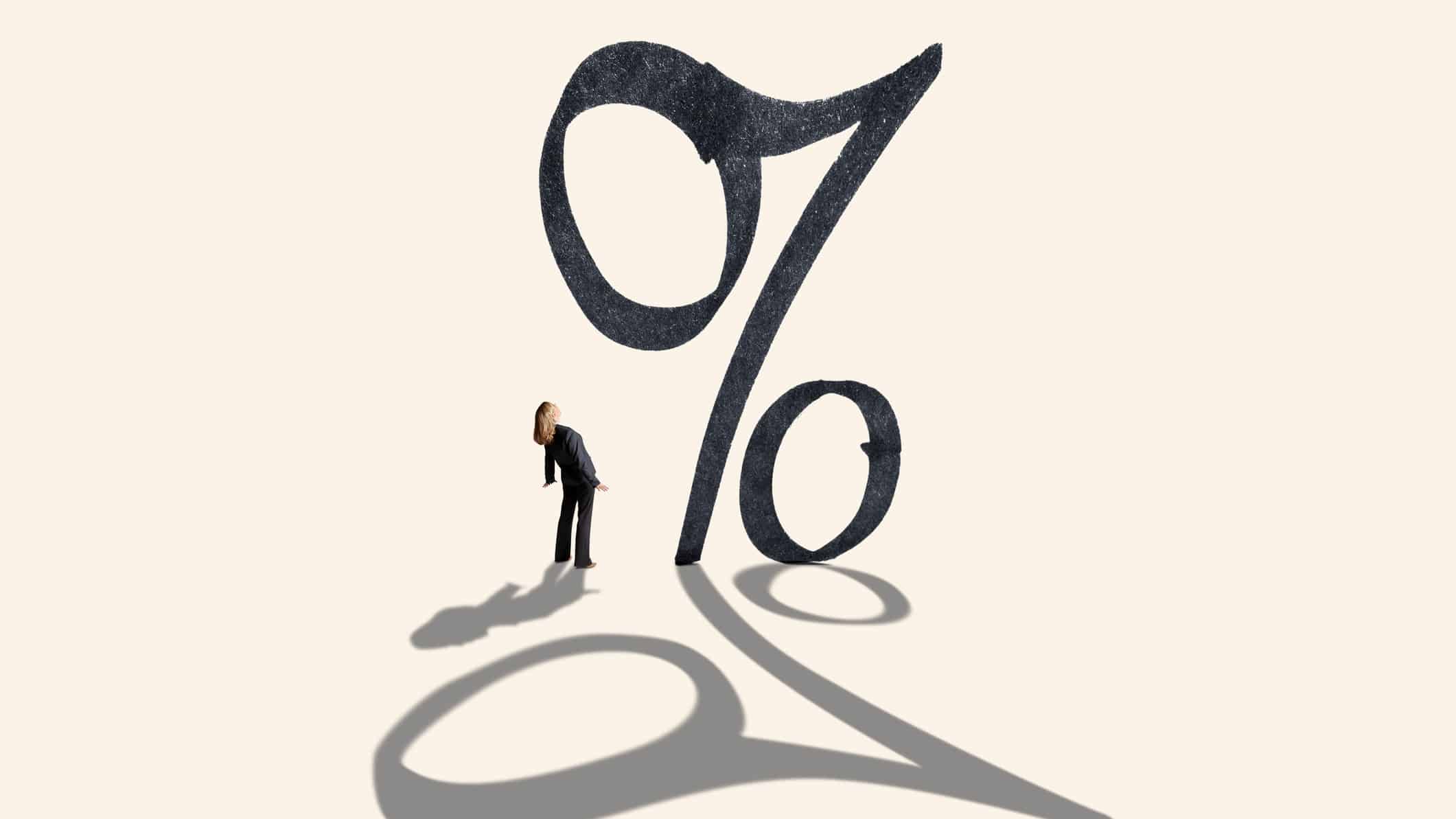 Big percentage sign with a person looking upwards at it.