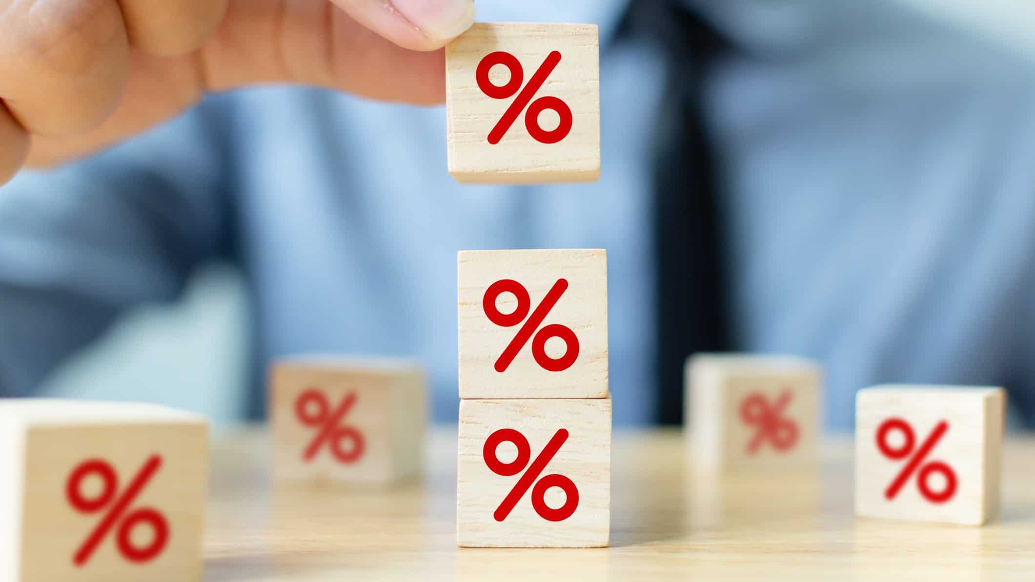 Red percentage sign on blocks on top of each other, symbolising interest rates.