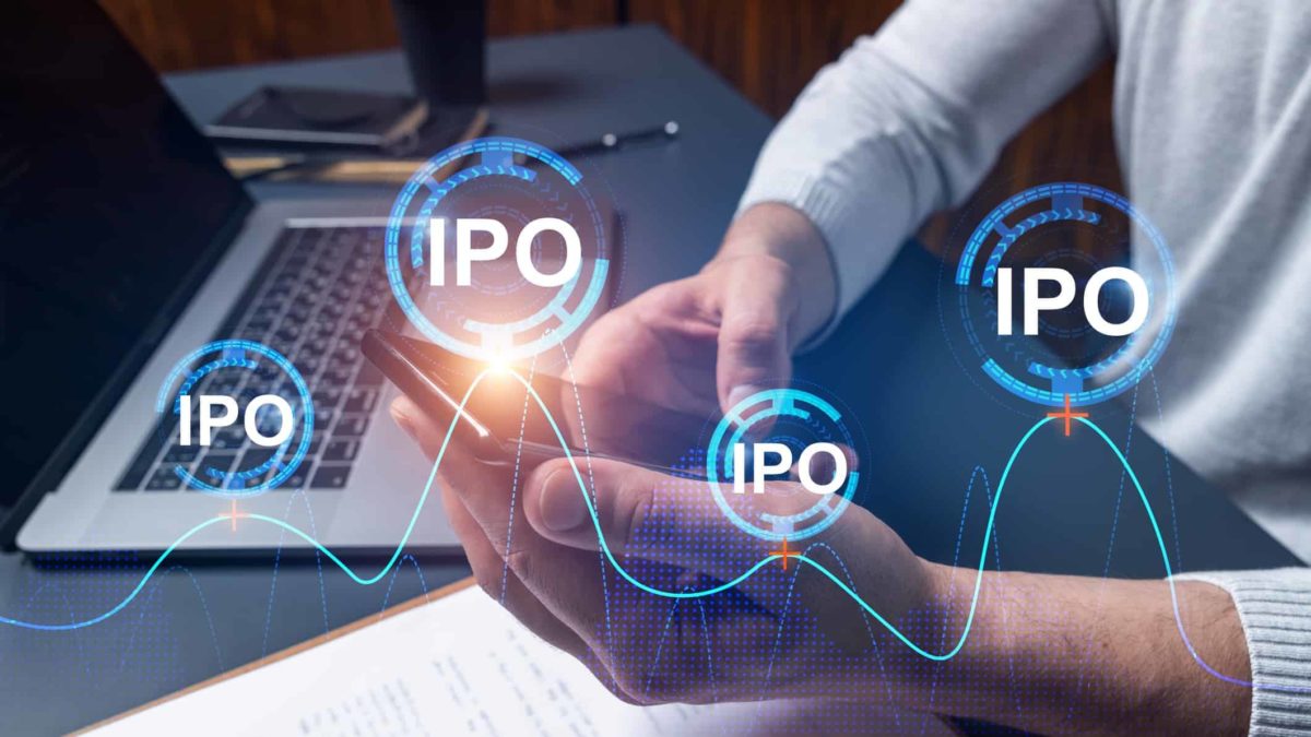 IPO written in circles with a man holding a smartphone and a laptop open.