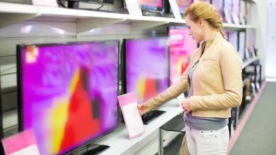 Woman checking out new TVs.