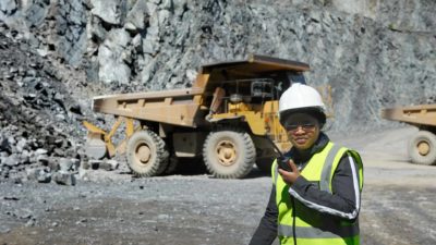 Female miner on a walkie talkie.