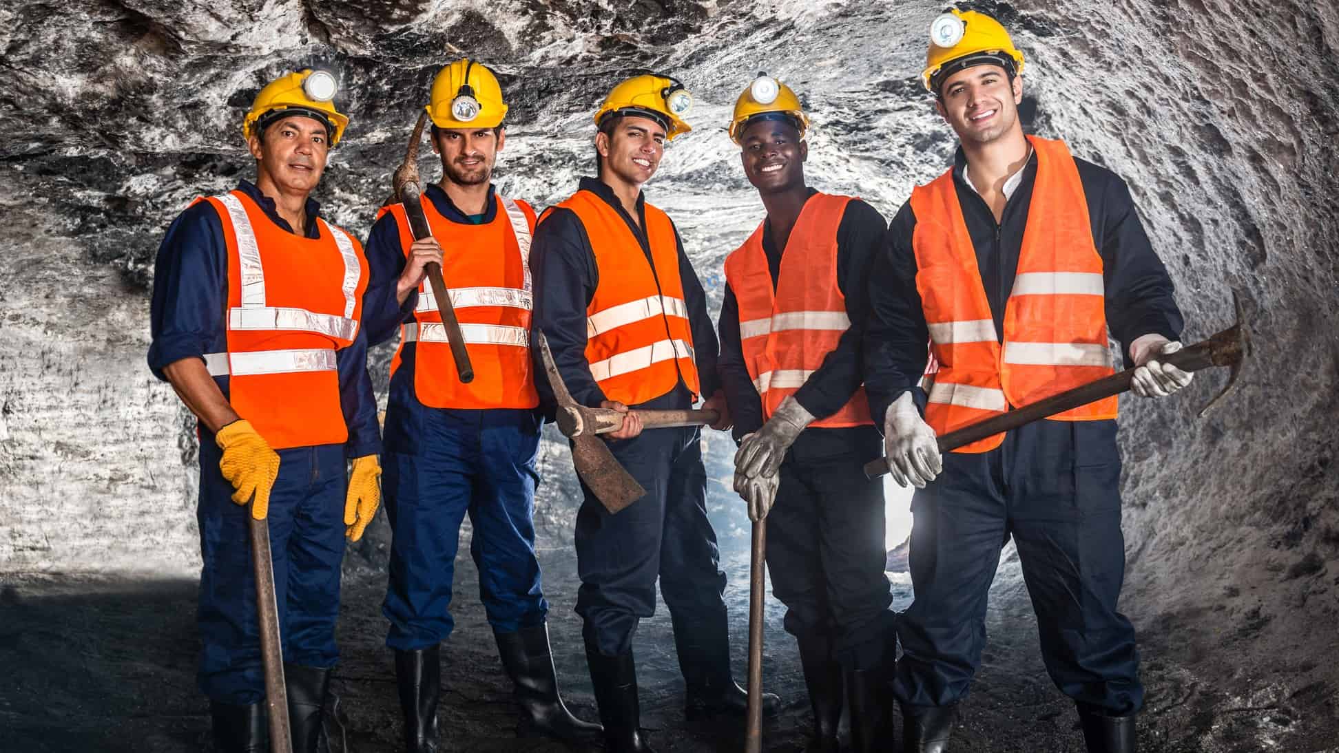 Five happy miners standing next to each other.