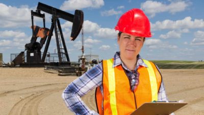 Oil rig worker standing with a clipboard.