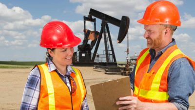 Two workers at an oil rig discuss operations.