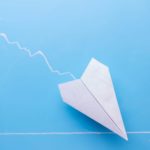 Paper aeroplane going down on a chart, symbolising a falling share price.