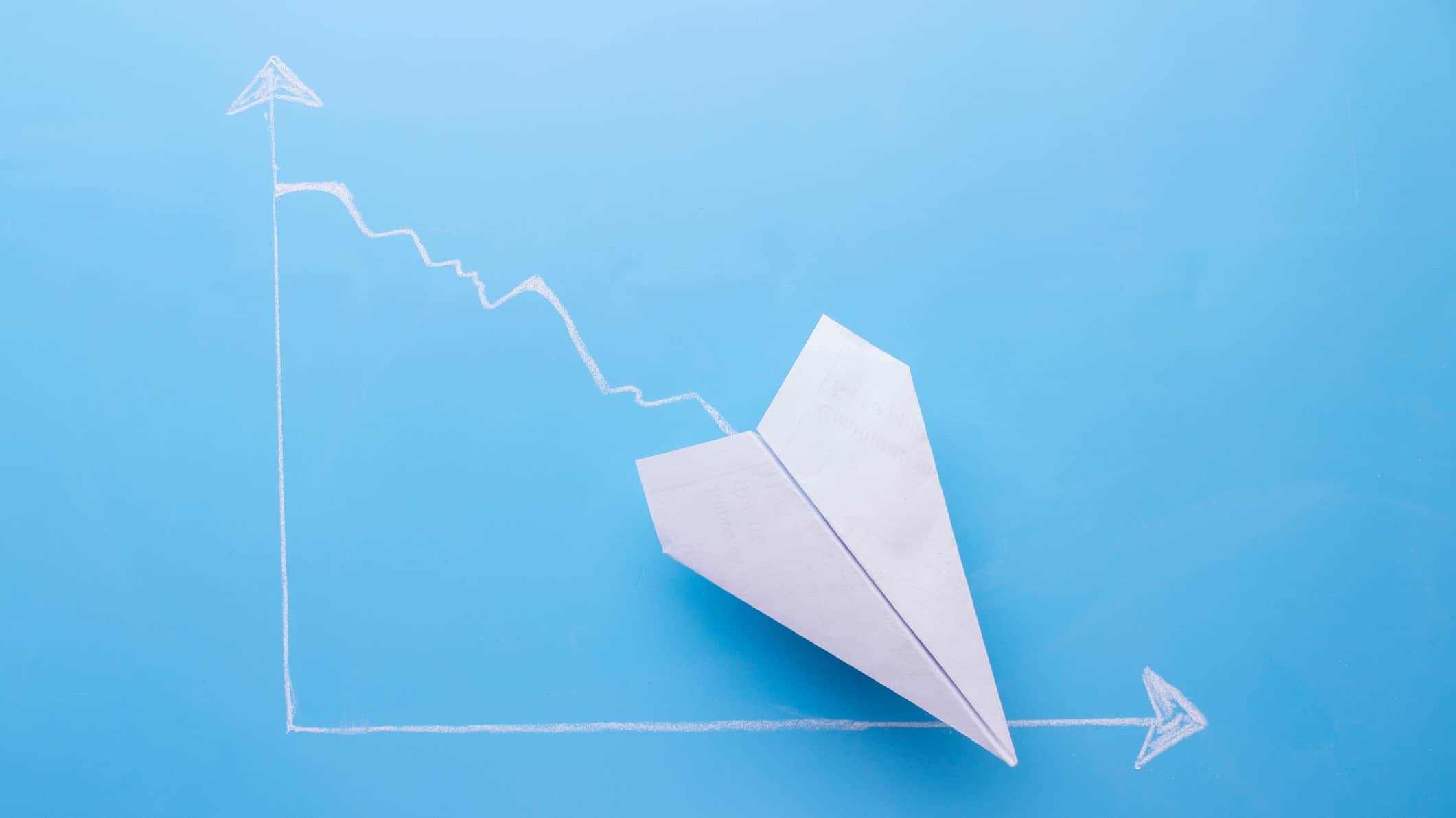 Paper aeroplane going down on a chart, symbolising a falling share price.