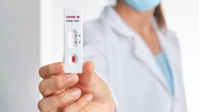 Woman holding a rapid antigen test.