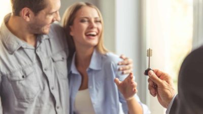 Happy couple receiving key to apartment.