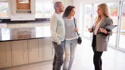 A couple talks with a real estate agent in a unit, representing the Lifestyle Communities share price today