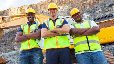 Three satisfied miners with their arms crossed looking at the camera proudly