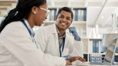 Two happy scientists analysing test results in a lab