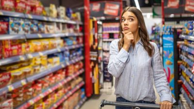 Woman thinking in a supermarket.