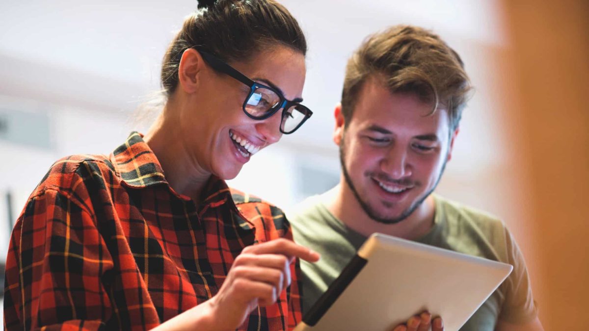 Happy woman and man looking at an iPad.