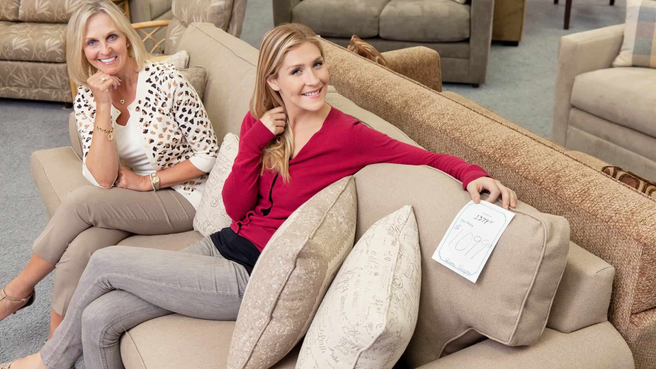 Two happy woman on a sofa.