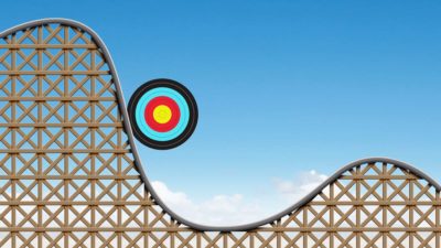 Target circle going down on a rollercoaster, symbolising volatility.