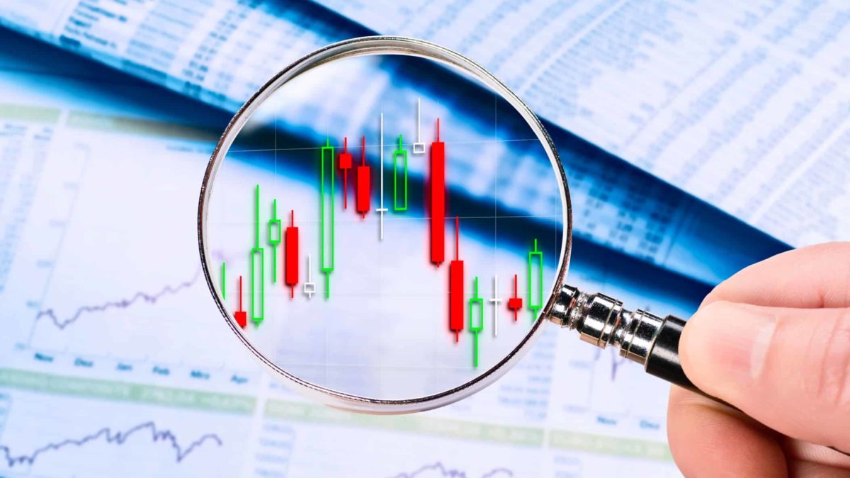 Magnifying glass on red and green points, symbolising volatility.