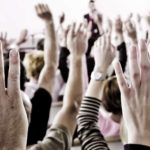 People raise their hands to vote.