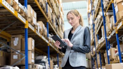 Woman looking at her tablet at a warehouse.