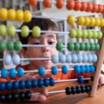 A boy's eyes pop wide open as he calculates something on his abacus.
