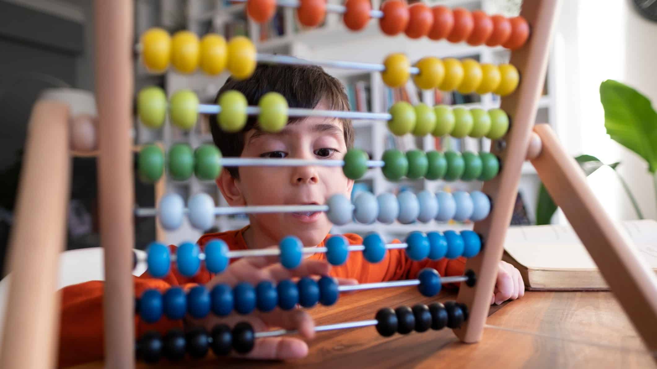 A boy's eyes pop wide open as he calculates something on his abacus.