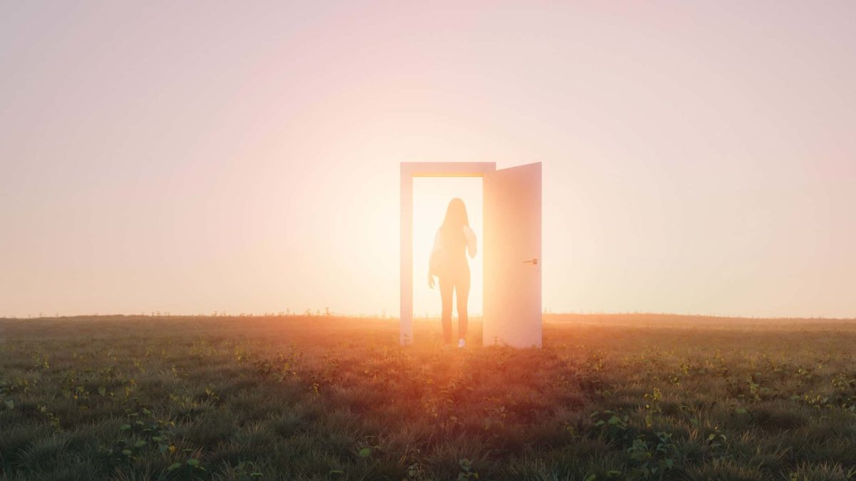 A person transforms as they walk through a doorway in a field towards a shining light.