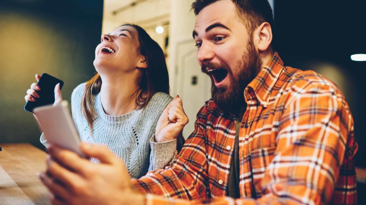 A couple are shocked and elated at the good news they've just seen on their devices.