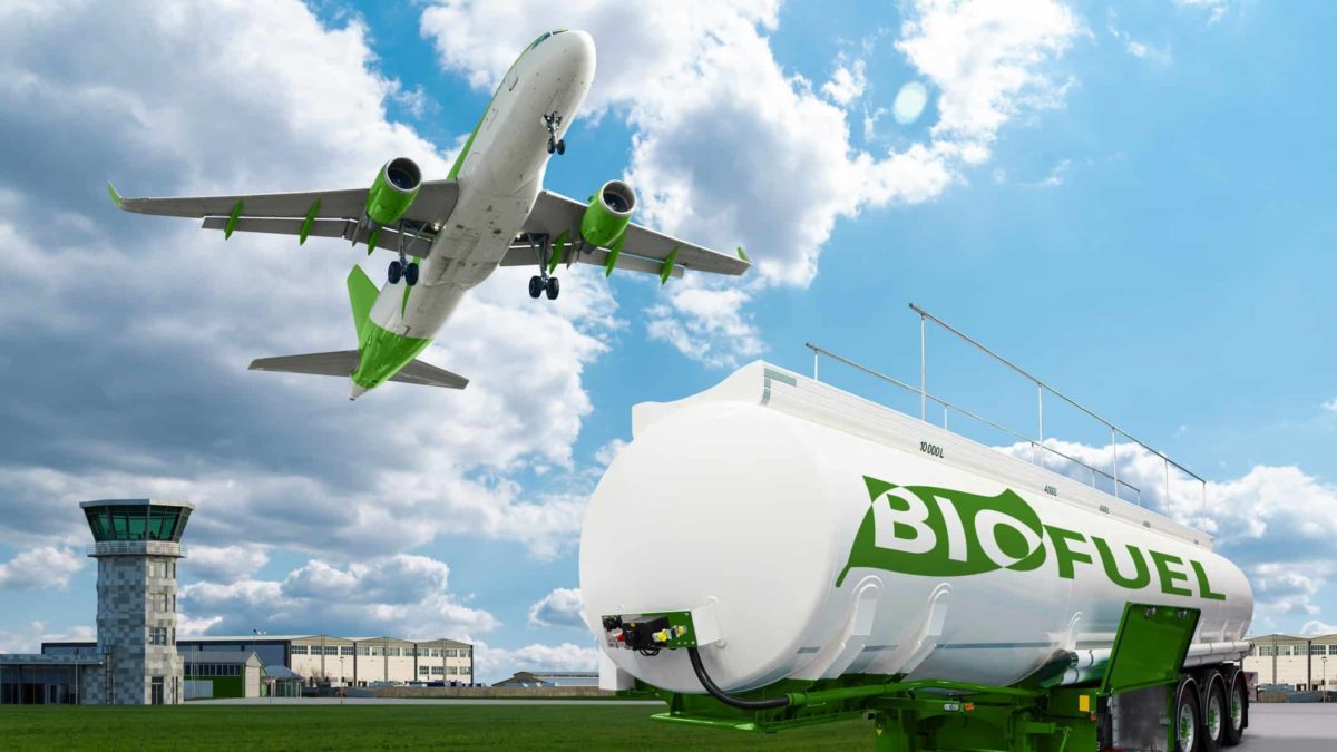 A green plane flies over a biofuels tanker.