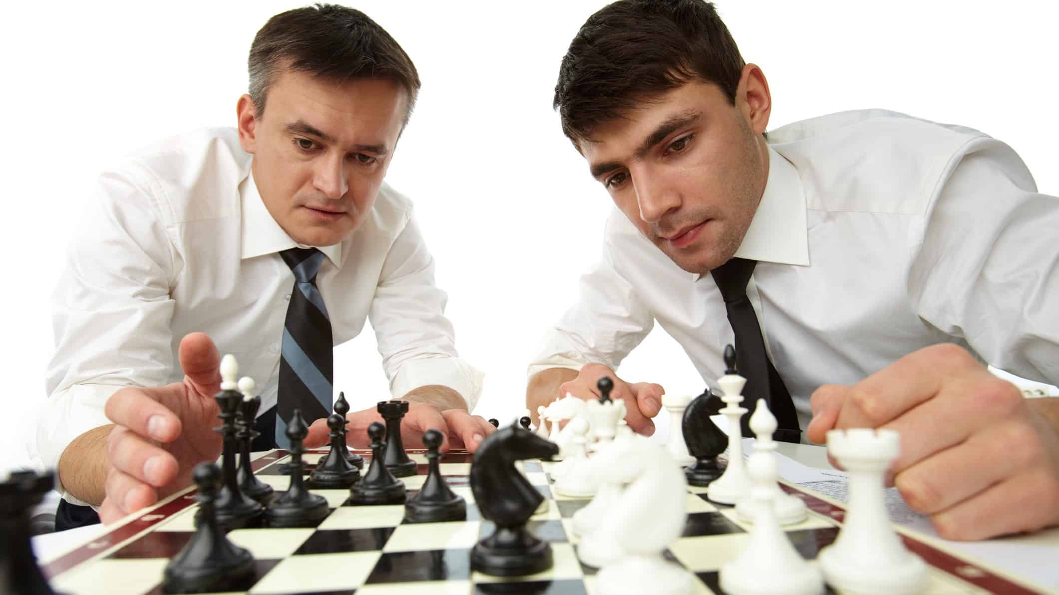Two men in business attire play chess.