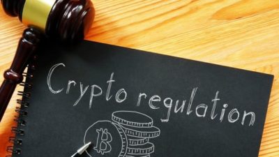 Gavel on a sign saying crypto regulation.