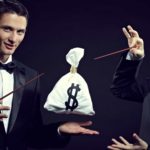 two magicians wearing dinner suits with bow ties wave their magic wands over a levitating bag with a dollars sign on it.